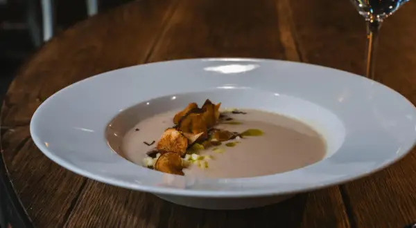 Krämig soppa med krispiga chips och olivolja, serverad på Radisson Blu Helsingborg restaurang.