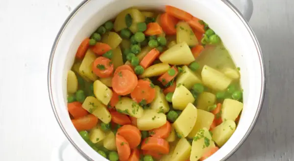 Ein Topf mit Kartoffeln, Karotten und Erbsen, ein einfaches und leckeres erbsen rezept.