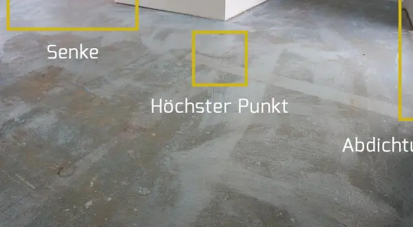 Der Boden wird vorbereitet, um die Ausgleichsmasse zu versiegeln. Markierungen zeigen Senken, den höchsten Punkt und die Abdichtung.