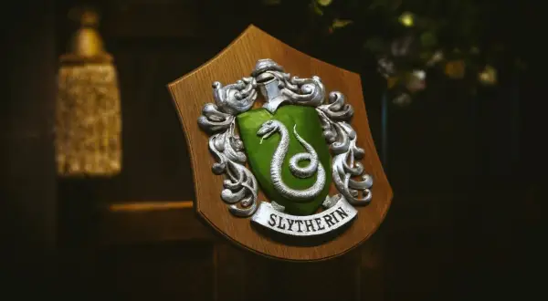 Herb Hogwartu, herb Slytherinu z zieloną tarczą i srebrnym wężem, dumnie prezentuje swoje barwy.