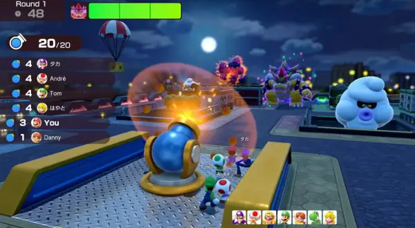 Postacie z Mario Party Jamboree w nocy, Bowser i Boo patrzą na armatę.