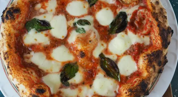 Eine perfekt gebackene Pizza Margherita mit geschmolzenem Mozzarella und frischem Basilikum.