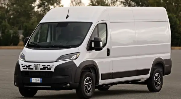 Biały Fiat Ducato Maxi, gotowy do transportu towarów, stoi na tle drzew.