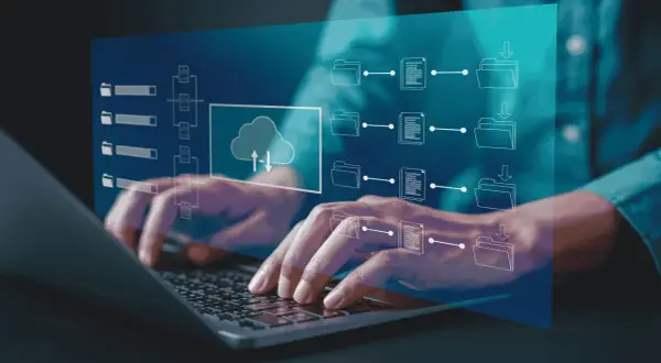 Mani che digitano su un laptop, con un'interfaccia digitale che mostra flussi di dati e icone di cartelle, simboleggiando la gestione dei processi con un sistema **erp aziendale**.