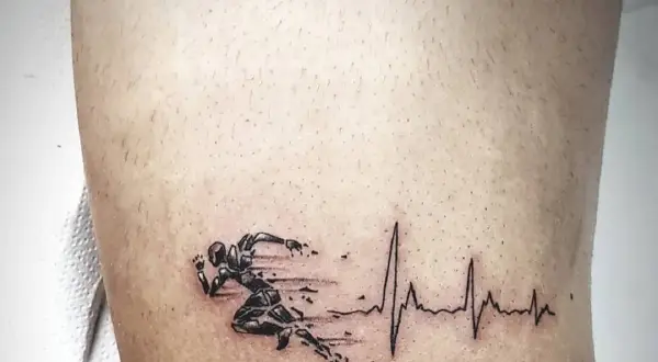 Tatuaż bieganie: sylwetka biegacza z EKG, symbolizująca pasję do sportu i życie w ruchu.