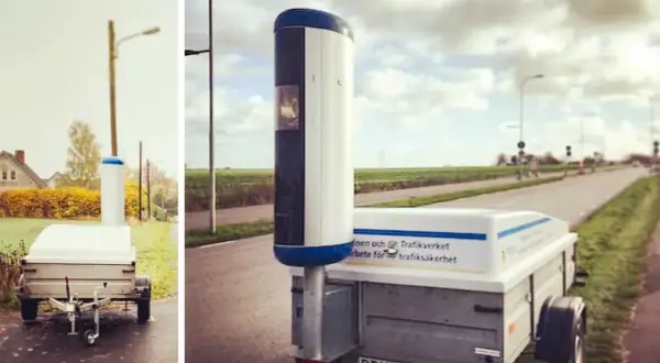 Mobil fartkamera på släp vid vägkanten. Enligt skylten arbetar Trafikverket för trafiksäkerhet.
