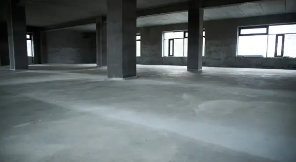 Surowa posadzka betonowa w pustym domu, idealna baza pod wykończenie. Jaki beton na posadzkę w domu wybrać?