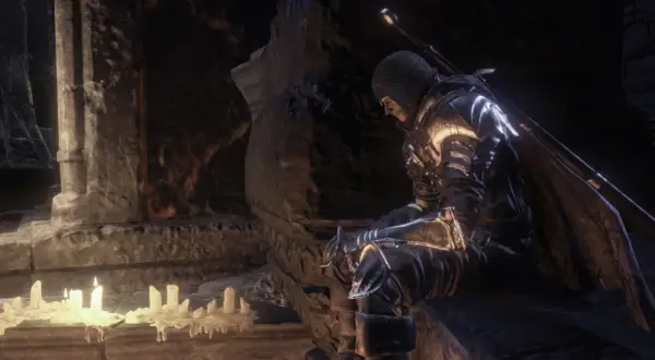 Rycerz w zbroi siedzi przy świecach, szukając wskazówek w **Dark Souls 3 poradnik**.