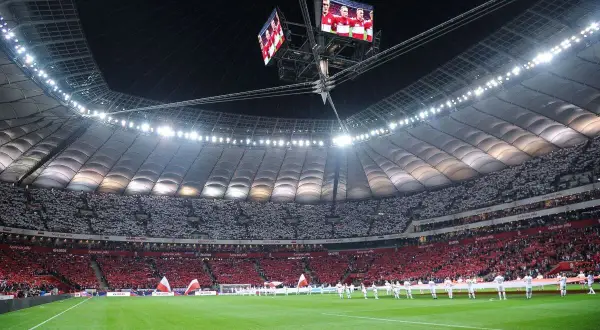 Stadion Narodowy w Warszawie, wypełniony po brzegi kibicami, gotowy na mecz. Zastanawiasz się, ile miejsc ma stadion narodowy? To imponująca arena!