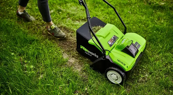 Zielona glebogryzarka Greenworks z koszem na trawę, gotowa do pracy w ogrodzie. To narzędzie, które pomoże Ci zadbać o trawnik.