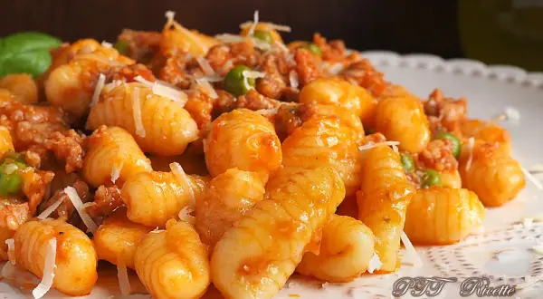 Gnocchetti sardi con ragù e piselli, un piatto gustoso ispirato alle ricette della Sardegna.