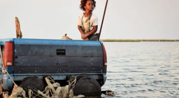 Un bambino su un pick-up galleggiante, un'immagine toccante per un film sull'ambiente per ragazzi.
