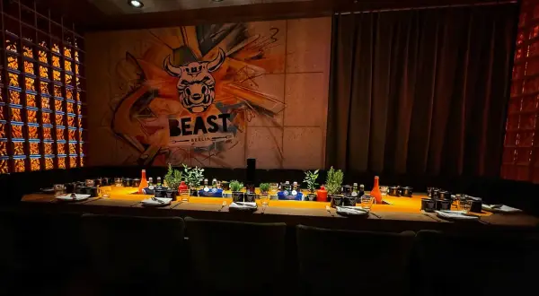 Ein festlich gedeckter Tisch im Alexanderplatz Restaurant "BEAST BERLIN" mit Graffiti-Wand und Glasbausteinen.