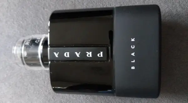 Elegancka, czarna butelka perfum Prada Black z białym logo.
