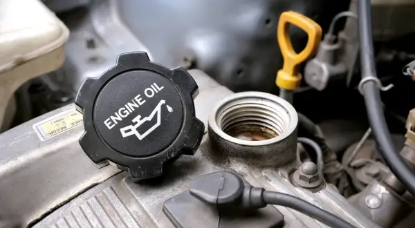 Korek silnika z napisem "ENGINE OIL" i symbolem kropli oleju. Pamiętaj o wymianie oleju co 2 lata dla sprawnego działania silnika.