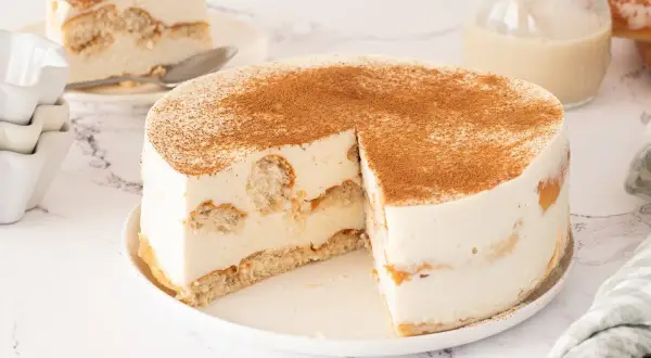 Tarta de horchata y fartons, cremosa y espolvoreada con canela. Una porción ya servida.