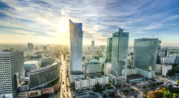 Słoneczny dzień nad nowoczesną lewobrzeżną dzielnicą Warszawy. Wysokie budynki biurowe i mieszkalne tworzą imponującą panoramę miasta.