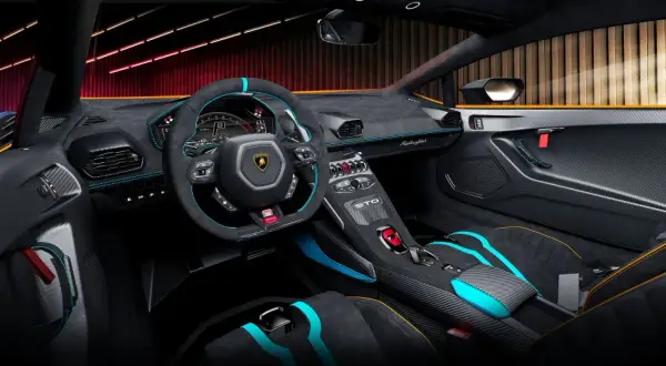 Wnętrze Lamborghini Huracan STO: sportowe fotele, kierownica z alcantary i włókna węglowego, cyfrowe zegary.