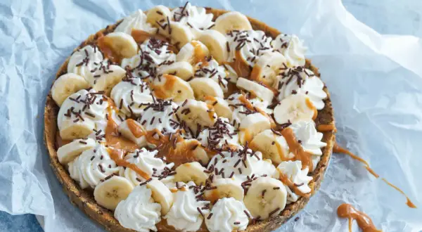 En läcker banoffee paj i glas, toppad med bananskivor, vispgrädde, kolasås och chokladströssel. Perfekt för en fika!