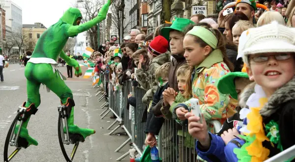 Zielony ludek na szczudłach podczas parady. Gdzie kupić piwo irlandzkie zielone? Może na festynie!