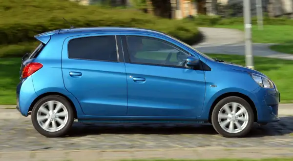 Niebieski Mitsubishi Space Star w ruchu. Wiele osób szuka Mitsubishi Space Star opinie, ten samochód miejski jest idealny do miasta.