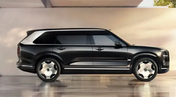 Svart Zeekr 9X SUV med silverdetaljer och unika fälgar, parkerad på ett glänsande golv.