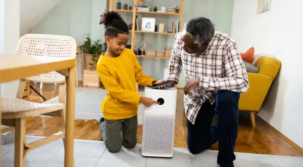 A boy and his grandfather learn how to test air quality in your home using a modern air purifier.