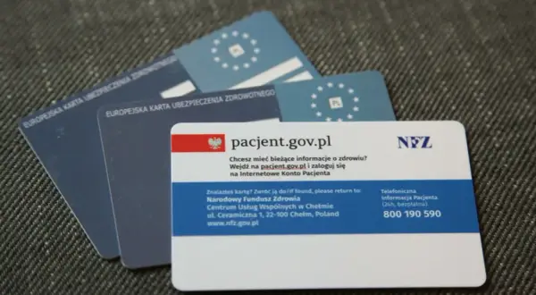 EKUZ, czyli Europejska Karta Ubezpieczenia Zdrowotnego, to dokument potwierdzający prawo do świadczeń medycznych w UE. Na zdjęciu widać kilka takich kart.