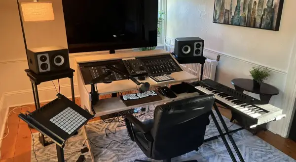 Ein Musikstudio mit einem großen Bildschirm, Mischpult, Tastatur und einem Plattenspieler für das perfekte **vinyl setup**.