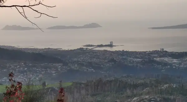 Vista panorámica desde el monte alba: islas Cíes, ciudad costera y bosques.