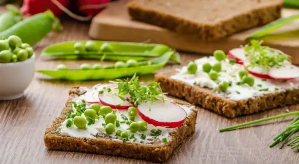 Frisches Vollkornbrot mit Frischkäse, Erbsen, Radieschen und Kresse – ein gesunder Aufschnitt für jeden Tag.