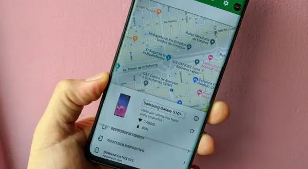 Mano sujetando un móvil que muestra la función de localizar móvil. Se ve un mapa de la Ciudad de México y opciones para reproducir sonido o proteger el dispositivo.