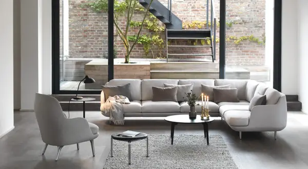 Modernes wohnzimmer mit 2 Sofas, einem Sessel und großem Fenster zum Garten mit Treppe.