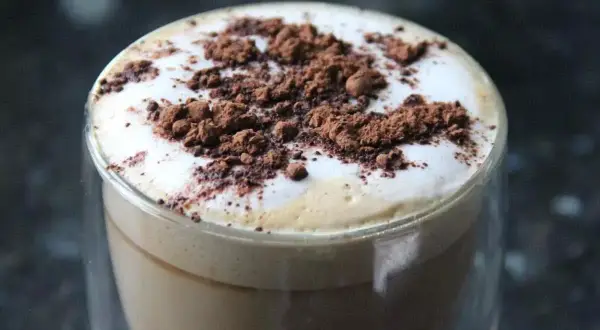 Cappuccino con schiuma soffice e cacao in polvere, un esempio di come montare il latte senza montalatte per un caffè perfetto.
