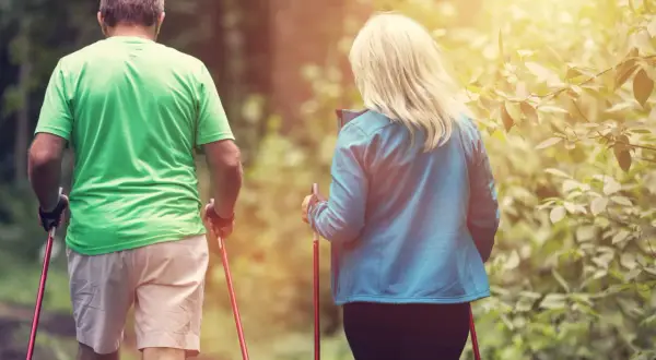 Couple en randonnée. Combien de pas par jour pour une femme de 65 ans ? L'activité physique est essentielle pour rester en forme.