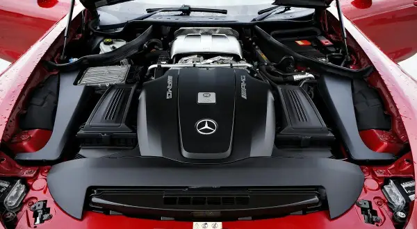 Le capot ouvert révèle le puissant moteur AMG d'une Mercedes rouge. Ce moteur, bien que différent d'un moteur Renault, est une merveille d'ingénierie.