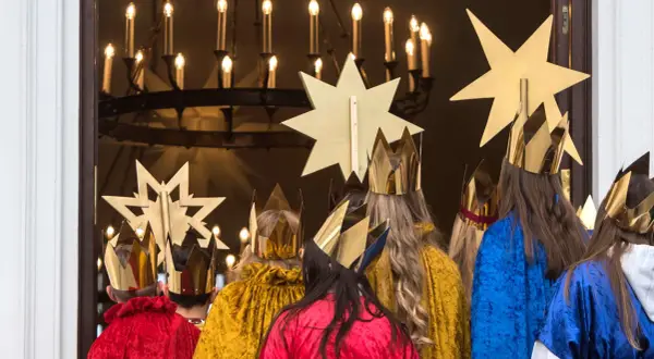 Sternsinger in goldenen Kronen und bunten Gewändern, bereit für den 7. Januar, das Weihnachtsfest.