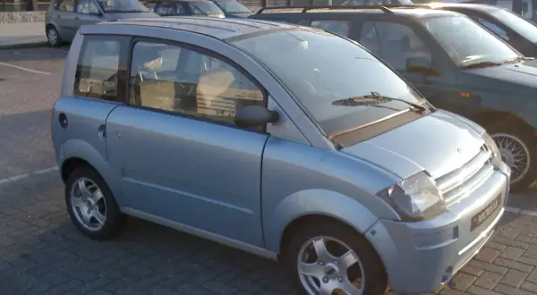 Jasnoniebieski, miejski auto od 16 lat, zaparkowane na kostce brukowej.