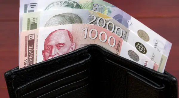 Czarny portfel wypełniony banknotami serbskie dinary. Widać nominały 1000 i 2000.