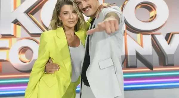 Para z uśmiechem pozuje na tle napisu "Koło Fortuny".