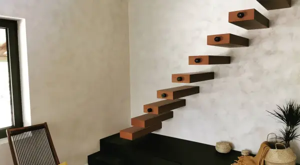 Escaliers flottants en bois sur un mur texturé, une belle deco peinture murale moderne.
