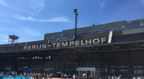 Människor samlas framför den ikoniska byggnaden för Berlins gamla flygplats, Tempelhof.