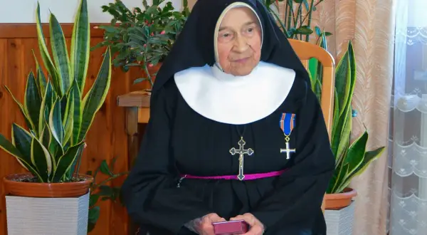 Siostra Antygony, w habicie i z krzyżem, siedzi wśród roślin. Może to być rozwiązanie krzyżówki z jej udziałem.