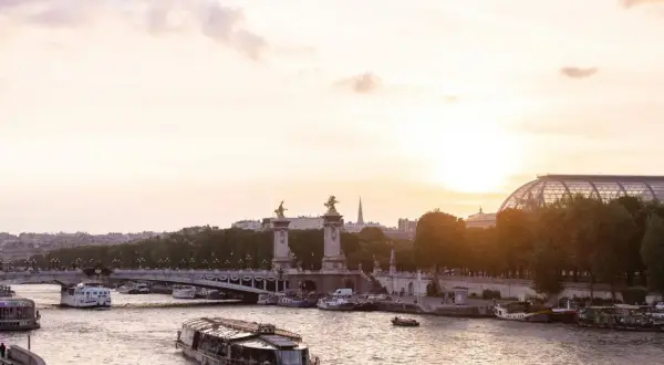 Boote auf der Seine bei Sonnenuntergang, eine malerische Szene, die die beste Reisezeit Paris widerspiegelt.