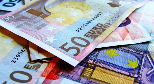 Stos pięćdziesięcioeuroowych banknotów. Widać fragmenty z cyfrą 50 i napisem "EURO".