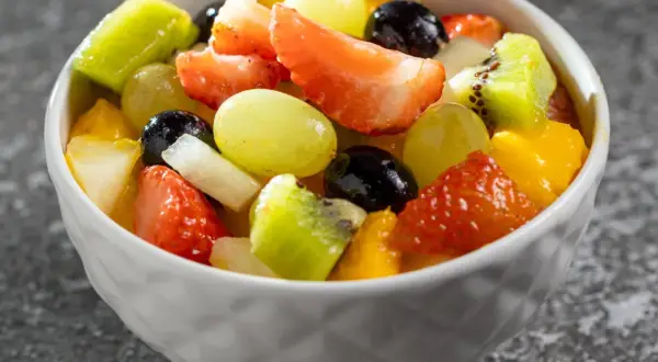 Kolorowa sałatka owocowa z truskawkami, kiwi, winogronami i mango. Idealna na lato, dowiedz się jak przygotować sałatkę owocową która nie ciemnieje przez kilka godzin.