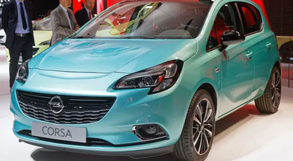Türkisfarbener Opel Corsa mit Schriftzug "Corsa" auf dem Kühlergrill.