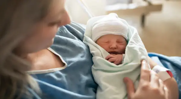 Matka tuli noworodka, czując radość z narodzin. To piękny początek ich wspólnej drogi, wspierany przez świadczenie rodzicielskie.