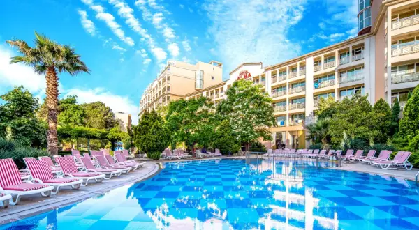 Basen i leżaki przy hotelu Alba w Bułgarii. Słoneczny dzień, błękitne niebo i palmy tworzą wakacyjny klimat.