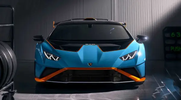 Niebieski Lamborghini Huracan STO z pomarańczowymi akcentami, gotowy do wyjazdu na tor.